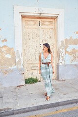 Beautiful young woman wearing fashionable clothes walking down the street