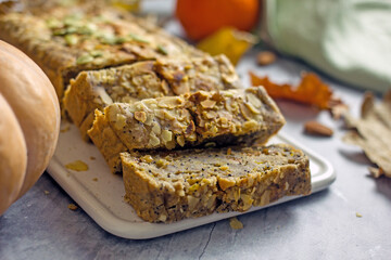 Vegan pumpkin pie with honey, poppy seeds and dried fruits. Homemade cupcake  sugar free cut into pieces on a white table, close-up