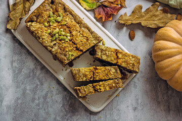 Gluten free and sugar free pumpkin bread cut into pieces. Pumpkin cake with dried fruits, poppy seeds and honey on a dark table. Copy space, flat lay, top view Vegan Pumpkin Pastry