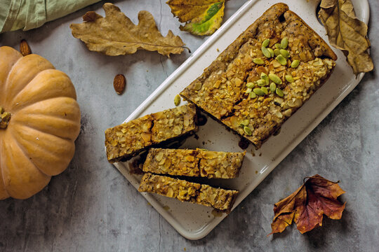 Gluten free and sugar free pumpkin bread cut into pieces. Pumpkin cake with dried fruits, poppy seeds and honey on a dark table. Copy space. Vegan Pumpkin Pastry