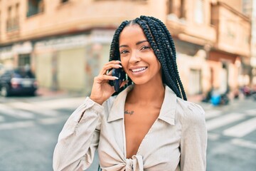 Young african american woman smiling happy talking on the smartphone at the city.