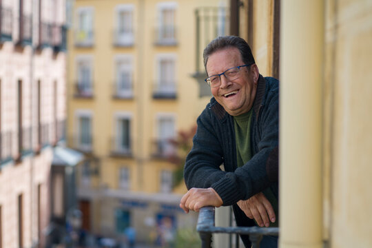 Lifestyle Portrait Of Happy And Cheerful Mature Man 65 To 70 Years Old At Home Balcony Feeling Positive And Relaxed Enjoying Retirement Smiling To The Street View