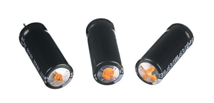 Damaged obsolete aluminium electrolytic capacitors isolated on white background. Three cracked electrical energy storage devices with leaked liquid electrolyte. High equivalent series resistance. Eco.