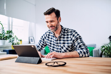 Man working from home using digital tablet