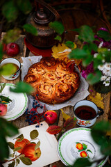 Naklejka na ściany i meble Apple buns with caramel on a wooden table in an autumn garden