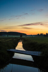 Obraz na płótnie Canvas Sunset over river and fields