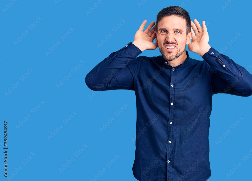 Sticker young handsome man wearing casual shirt trying to hear both hands on ear gesture, curious for gossip