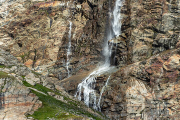 High-altitude Alpine waterfalls in Says-Fee. In Summer melting ice from Fee Glacier (Feegletscher) is the source of multiple waterfalls and streams that flow into Saas Valley to build Fee Vispa river.