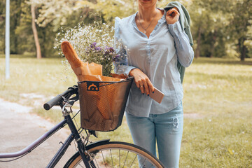 Stylish woman riding a bicycle and using a cellphone.