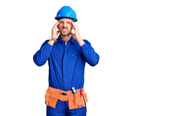 Young handsome man wearing worker uniform and hardhat touching forehead for illness and fever, flu and cold, virus sick