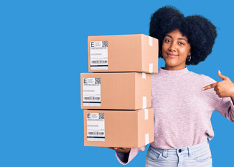 Young african american girl holding delivery package pointing finger to one self smiling happy and...
