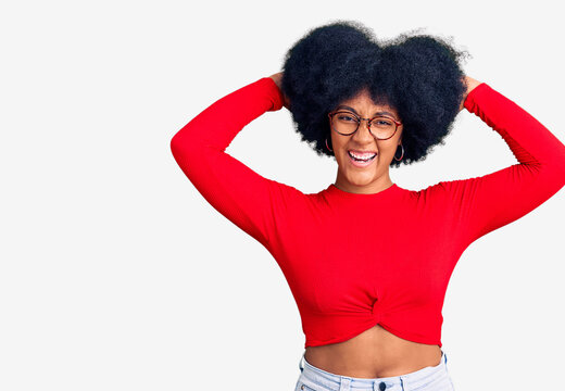 Young african american girl wearing casual clothes and glasses relaxing and stretching, arms and hands behind head and neck smiling happy