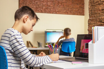 Online learning, remote education, distance learning, entertiment at home. Kids using laptop computers for homework