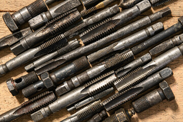 Old vintage hand tools - drills and threading die on a wooden background