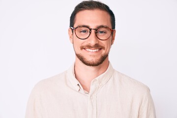 Young handsome man wearing casual clothes and glasses looking positive and happy standing and smiling with a confident smile showing teeth