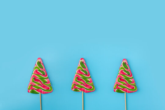 Christmas candies on blue background. Candy shapes, candy cane. Flat lay, top view. Copy space