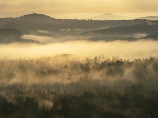 Blick in den Morgenstunden von den Affensteinen über Alten Wildenstein Richtung Lichtenhain. Die Sonne schickt ihre ersten wärmenden Strahlen durch den dichten Nebel in die Bergwelt des Nationalparkes