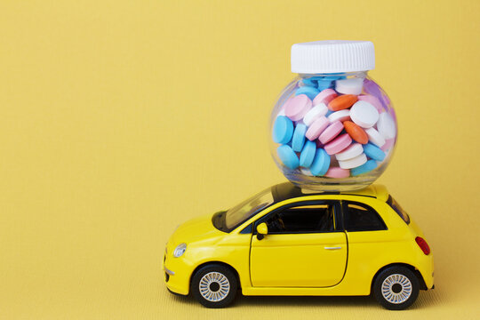 yellow toy car delivering a bottle of drugs and pills.  Internet pharmacy, online order home delivery. 