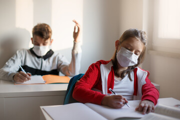 Children with face masks in school, after covid-19 quarantine and lockdown.