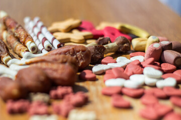 Dog tasty colored biscuits on wooden background 