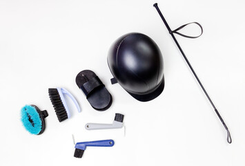 Flat lay of equestrian gear: helmet, brushes, whip, bandages, stirrups, pads, dressage, bridle....