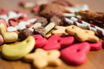 Dog tasty colored biscuits on wooden background 