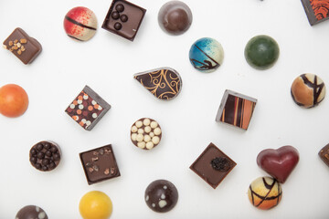 lot of variety chocolate pralines, top view of various chocolate pralines isolated on white background