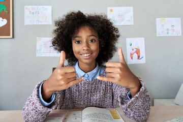 Happy african deaf mute kid school girl learning online class on laptop looking at webcam...
