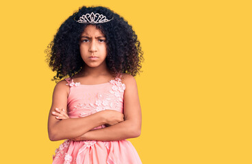 African american child with curly hair wearing princess crown skeptic and nervous, disapproving expression on face with crossed arms. negative person.