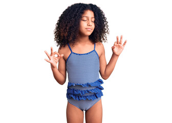 African american child with curly hair wearing swimwear relax and smiling with eyes closed doing meditation gesture with fingers. yoga concept.