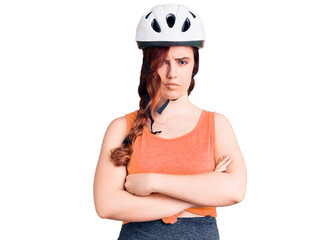 Young beautiful woman wearing bike helmet skeptic and nervous, disapproving expression on face with crossed arms. negative person.