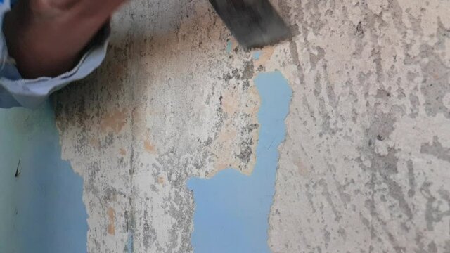 Peeling old paint off the wall with scraper. Peeling old paint off the wall with scraper, slow motion	