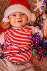 child with a christmas toy and in santa hat