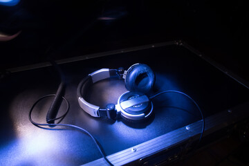Fototapeta na wymiar Dj music club concept. Close up headphones on dark background with colorful light.