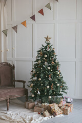 Christmas tree in the Scandinavian style. Cozy minimalism living room decor. New Years celebration. Gifts under the tree. Rustic Xmas mood. Postcard vintage saver Hugge. 