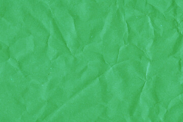 Green vintage and old looking crumpled paper background. Retro cardboard texture. Grunge paper for drawing. Ancient book page. Present wrapping.