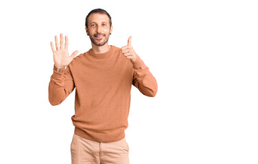 Young handsome man wearing casual clothes showing and pointing up with fingers number six while smiling confident and happy.
