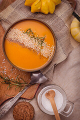 Top view of bowl with delicious pumpkin soup and spoon, salt and pumkins. Vegan Creamy Delicious Pumkin Soup. Copy space.