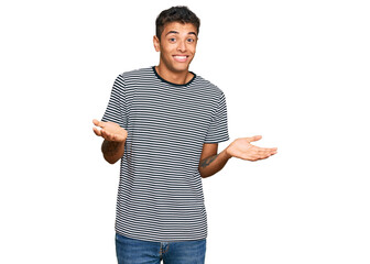 Young handsome african american man wearing casual clothes clueless and confused expression with arms and hands raised. doubt concept.