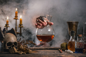 Alchemist is working by his magic table.