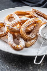 Tasty fried churros with sugar powder.