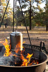 Making coffee over a camp fire in the woods while camping