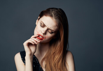 A woman with bright makeup smears lipstick on her face