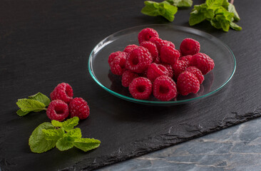 sweet juicy raspberries lie on a saucer