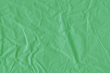 Green vintage and old looking crumpled paper background. Retro cardboard texture. Grunge paper for drawing. Ancient book page. Present wrapping.