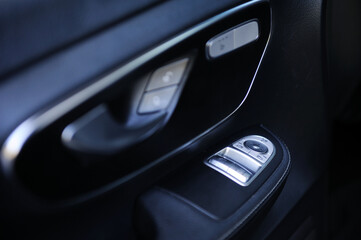 Fototapeta na wymiar close-up of the side door buttons: window adjustment buttons, door lock. modern car interior: parts, buttons, knobs