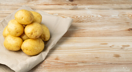 Raw Potatoes on Wooden Cutting Board Background