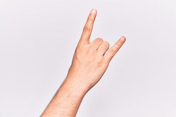 Close up of hand of young caucasian man over isolated background gesturing rock and roll symbol, showing obscene horns gesture