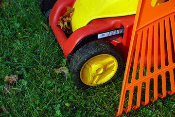 Lawn mower and rake. Autumn accessories for working in the garden.