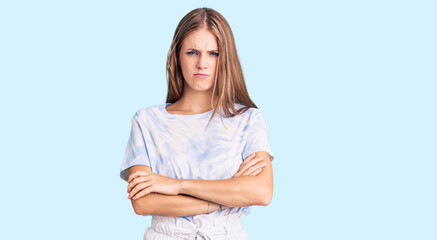 Young beautiful blonde woman wearing tye die tshirt skeptic and nervous, disapproving expression on...